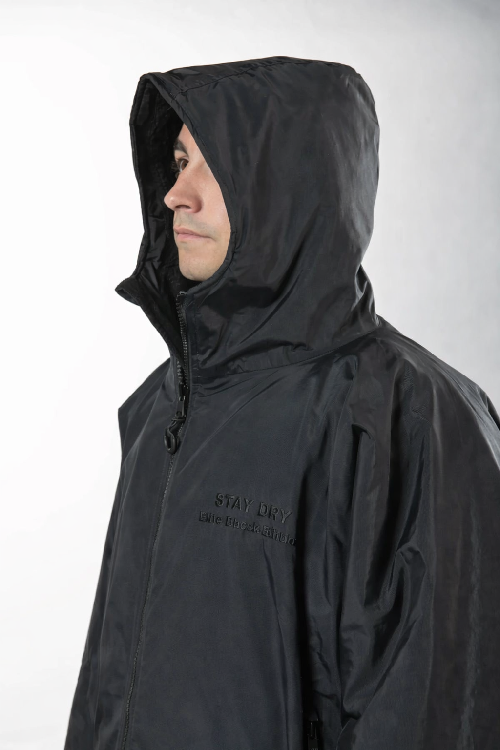 Person wearing a black raincoat with a hood on a white background