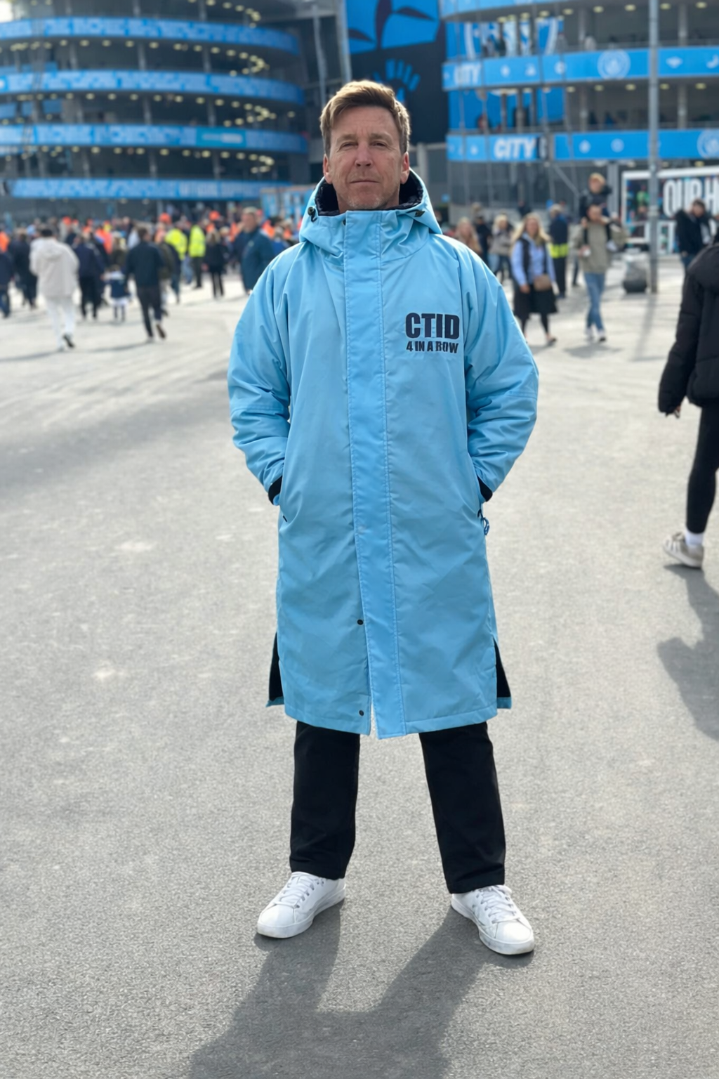 Person wearing a waterproof Manchester City football coat